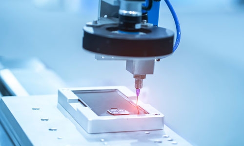 A light-curable adhesive is applied to a cell phone and processed on an automated assembly line.